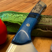 TANZO CUTLERY professional chef knife with a blue and burl wood handle resting on a wooden cutting board